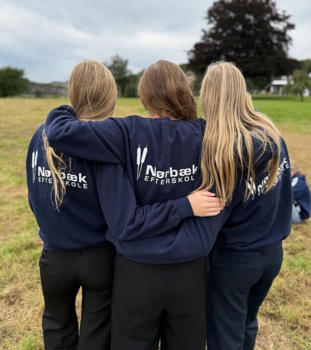 Tre elever fra Nørbæk Efterskole med skolens logo på ryggen